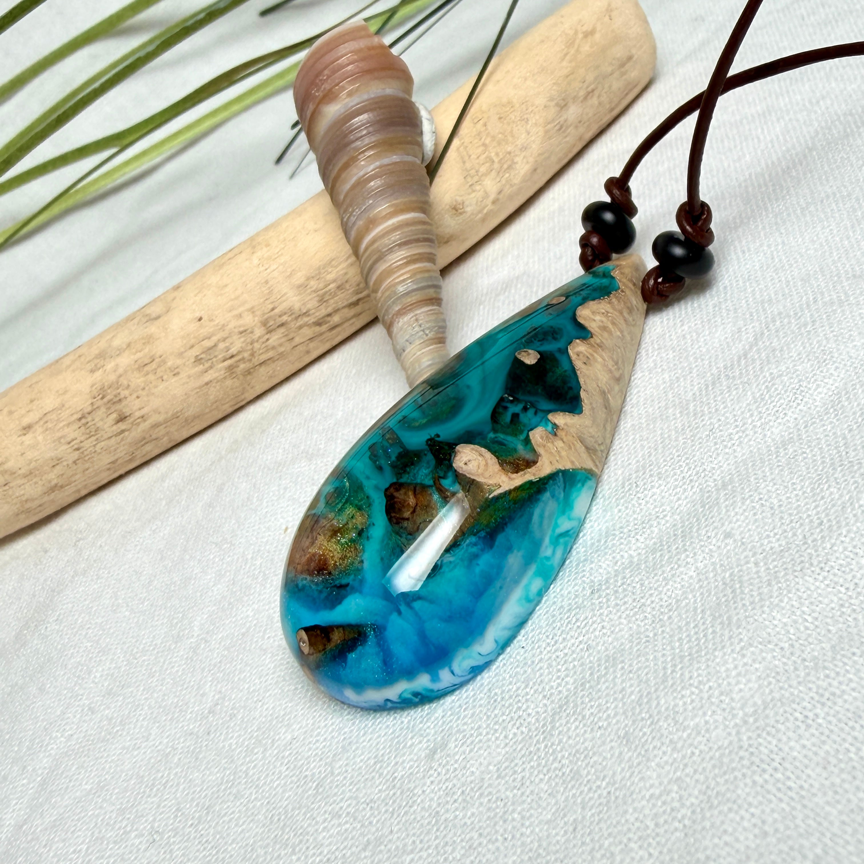 Holz-Harz-Anhänger aus Maserholz mit türkis-blauem Epoxidharz in Tropfenform am verstellbaren Lederband mit Onyxperlen, handgemachter maritimer Naturschmuck