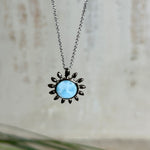 Feine Halskette aus rhodiniertem 925 Silber mit Sonnen-Anhänger und rundem Larimar-Cabochon, 10 mm. Der seltene, hellblaue Stein aus der Dominikanischen Republik erinnert an Meer und Himmel. Gesamtgröße des Anhängers ca. 20 x 19 mm, Ankerkette 45 cm, ca. 1 mm stark. Edler, maritimer Schmuck, geliefert in einer Geschenkbox.