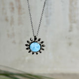 Feine Halskette aus rhodiniertem 925 Silber mit Sonnen-Anhänger und rundem Larimar-Cabochon, 10 mm. Der seltene, hellblaue Stein aus der Dominikanischen Republik erinnert an Meer und Himmel. Gesamtgröße des Anhängers ca. 20 x 19 mm, Ankerkette 45 cm, ca. 1 mm stark. Edler, maritimer Schmuck, geliefert in einer Geschenkbox.