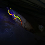 Handgefertigter Surfbrett-Anhänger aus Olivenholz und fluoreszierendem Harz in Gelb und Orange. Das leuchtende Harz beginnt unter Schwarzlicht intensiv zu strahlen und macht den Anhänger zu einem echten Highlight. Größe ca. 6,3 × 2 cm, mit Edelstahl-Anhängerschlaufe und Lederkette mit Edelstahlverschluss und 5 cm Verlängerung. Jedes Schmuckstück ist ein Unikat – Maserung und Farbspiel sind einzigartig. Ideal für Naturliebhaber und Individualisten.