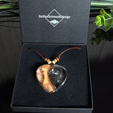 Herzanhänger „Pusteblumenzauber“ aus naturbelassenem Rebholz und klarem Epoxidharz mit schwebenden Pusteblumensamen. Dunkelbraunes, verstellbares Lederband mit kleinen Holzperlen, Anhänger ca. 3,5 × 3,5 cm. Handgefertigtes Unikat von ZeitlosSchmuckDesign.