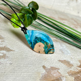 Handgefertigter Anhänger „Ocean Leaf“ aus Maserholz und Epoxidharz in Blau- und Türkistönen. Ein einzigartiges Schmuckstück, das die Schönheit von Natur und Meer einfängt. Mit verstellbarem Lederband (24–43 cm). Jeder Anhänger ist ein Unikat mit einzigartiger Maserung und Farbverlauf.