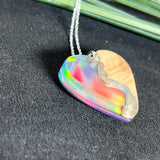Handgefertigter Herzanhänger aus Maserholz und schimmerndem Opalharz, inspiriert von den Farben der Aurora Borealis. Das Holz zeigt eine feine Maserung, das Harz leuchtet in Rosa-, Blau- und Violetttönen. Mit zarter 925 Silber-Ankerkette (1 mm stark, 45 cm lang) und Silberöse. Ein edles Unikat in liebevoller Handarbeit gefertigt.