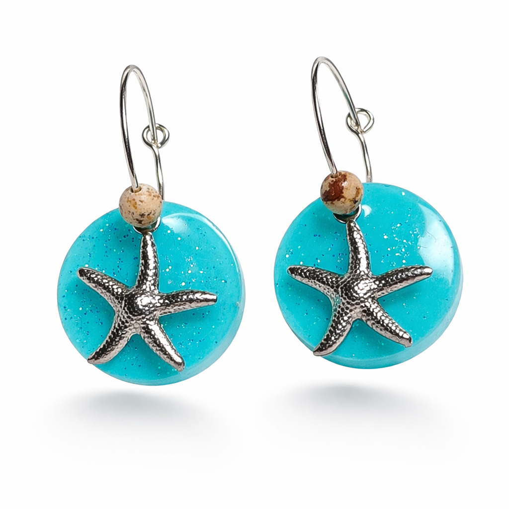 Handgefertigte Creolen-Ohrringe mit türkisblauer Resin-Scheibe, Glitzereffekt, silbernem Seestern-Charm und Jaspis-Natursteinperle. 925 Silber Creole, Gesamtlänge ca. 3,5 cm – Ocean-Feeling für jeden Tag.