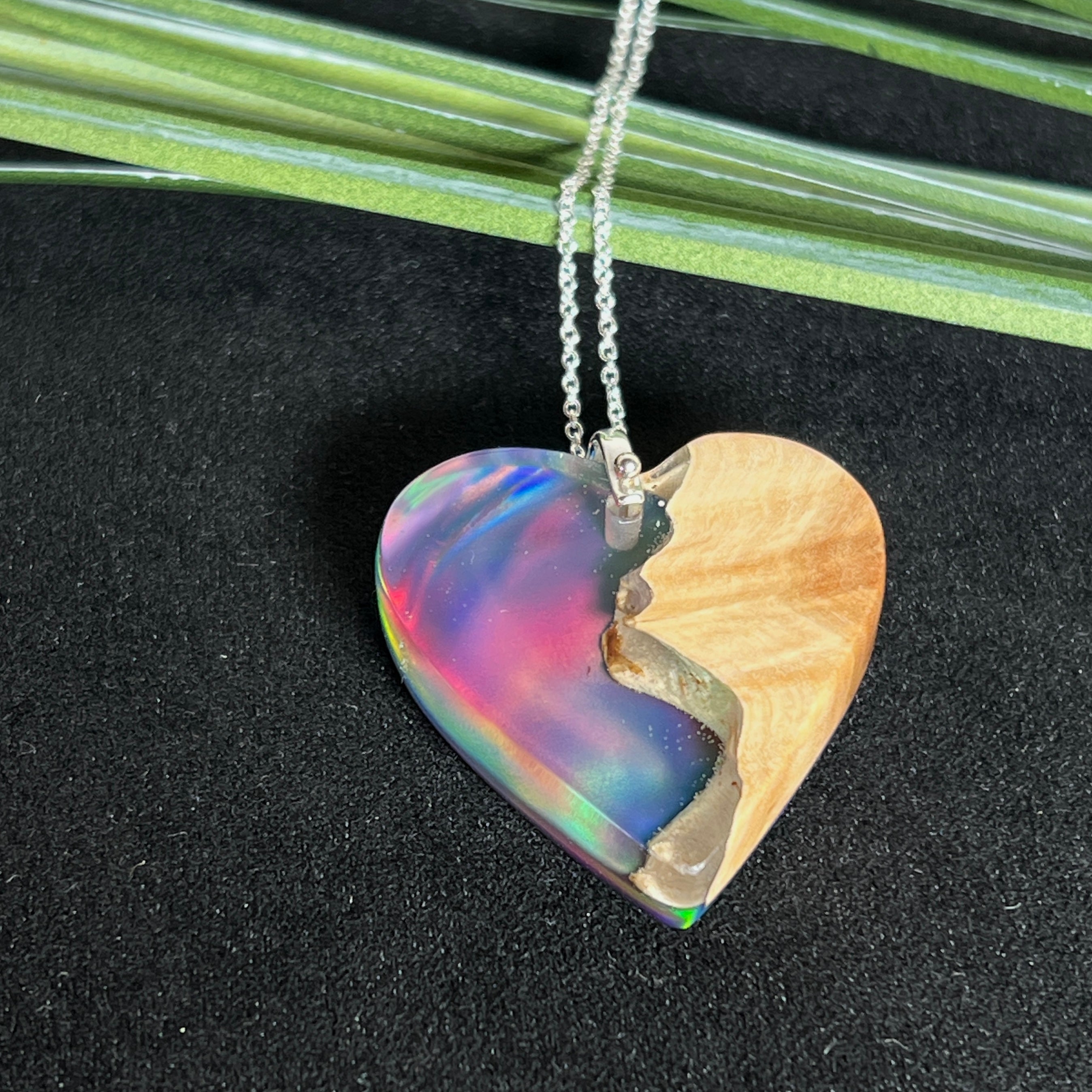 Handgefertigter Herzanhänger aus Maserholz und schimmerndem Opalharz, inspiriert von den Farben der Aurora Borealis. Das Holz zeigt eine feine Maserung, das Harz leuchtet in Rosa-, Blau- und Violetttönen. Mit zarter 925 Silber-Ankerkette (1 mm stark, 45 cm lang) und Silberöse. Ein edles Unikat in liebevoller Handarbeit gefertigt.