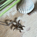 Feine Schildkröten-Kette aus rhodiniertem 925 Silber. Im Panzer des Anhängers liegt ein tropfenförmiger Larimar in hellem Blau. Der Anhänger ist ca. 22 x 18 mm groß und hängt an einer 45 cm langen, 1 mm starken Silberkette.