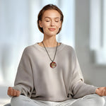 Handgefertigtes Medaillon aus klarem Epoxidharz mit kunstvollem rot-silber-weißen Farbverlauf und einem goldenen Samen des Lebens Symbol in der Mitte. Das spirituelle Schmuckstück strahlt Harmonie, Wachstum und Schutz aus. Rückseite mit individueller Harzstruktur, Vorderseite transparent glänzend. Anhänger mit verstellbarem schwarzen Baumwollband, auf hellem Hintergrund mit grünen Blätterni dekorativ inszeniert.