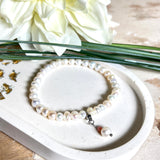 Handgefertigtes Armband „Ocean Bloom“ mit echten, schimmernden Süßwasserperlen (Ø ca. 6–7 mm) auf elastischem Band. Jede Perle ist ein Unikat mit natürlicher Form und sanftem Glanz. Highlight: Charmanhänger mit einer Süßwasserperle und einer facettierten Andenopal-Perle, befestigt an einem robusten Edelstahl-Karabiner. Ein Schmuckstück voller Eleganz, Symbolkraft und maritimer Schönheit.