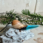 Handgefertigter Anhänger aus Edelholz und transparent-türkisblauem Epoxidharz, glatt poliert. Größe ca. 6,7 × 2,0 cm. Mit Edelstahlöse an schwarzer Lederkette (45 cm + 5 cm Edelstahl-Verlängerung, Karabiner). Maritimer, moderner Unisex-Schmuck mit natürlicher Holzmaserung; kleine Lufteinschlüsse sind charakteristisch.