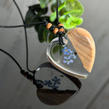 Handgefertigter herzförmiger Anhänger aus Olivenholz und Epoxidharz mit echten Vergissmeinnicht-Blüten und Pusteblumen-Samen, an verstellbarer schwarzer Lederkette mit Holzperlen, Unikat 