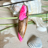 Handgefertigter Surfbrett-Anhänger „Pink Glow“ aus edlem Olivenholz und fluoreszierendem Epoxidharz in Pink & Weiß. Fluoreszierend bei Schwarzlicht, mit Edelstahl-Anhängerschlaufe und schwarzer Lederkette (45 cm + 5 cm Verlängerung). Ein maritimes Unikat – perfekt als Geschenk für Surfer und Meeresliebhaber.