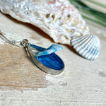 „Lagunenlicht“ – Tropfenanhänger mit handmodellierter 3D-Welle und feinem Glitzereffekt. Klarer Harzlook in Blau/Türkis, gefasst in Silber-Legierung. Größe ca. 3,5 × 2 cm. Geliefert an einer versilberten Kette (ca. 56 cm). Hochglänzend , maritimer Unikatcharakter.