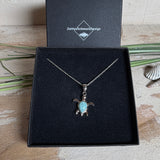 Feine Schildkröten-Kette aus rhodiniertem 925 Silber. Im Panzer des Anhängers liegt ein tropfenförmiger Larimar in hellem Blau. Der Anhänger ist ca. 22 x 18 mm groß und hängt an einer 45 cm langen, 1 mm starken Silberkette.