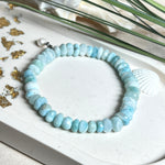 Handgefertigtes Armband aus seltenem Larimar mit facettierten, türkis-blauen Edelsteinperlen (Ø ca. 6–7 mm), elastischem Band und einem zarten Süßwasserperlen-Charm an Edelstahlkarabiner. Der wertvolle Larimar, auch „Stein des Atlantis“ genannt, gilt als Edelstein der Ruhe und Meeresverbundenheit.