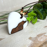 Herzanhänger „Pure Heart“ aus Maserholz und weißem Epoxidharz. Handgefertigtes Unikat mit kontrastreichem Design – die natürliche Maserung des Holzes trifft auf die klare Reinheit von Weiß. Größe ca. 3,5 × 3,5 cm. Verstellbares Lederband (23–41 cm) mit Holzperlen. Ein edles Schmuckstück, inspiriert von Natur und Liebe.