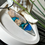 Handgefertigter Surfbrett-Anhänger aus Maserholz und transparentem Harz mit Farbverlauf in Blau und Weiß. Die natürliche Maserung des Holzes trifft auf ozeanartige Harzstrukturen. Größe ca. 6,7 x 2 cm, mit Edelstahlöse und Lederband inkl. Karabinerverschluss (45 cm + 5 cm Verlängerung). Jedes Stück ist ein Unikat – maritim, modern und mit viel Liebe gefertigt.