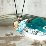 Handgefertigter Herzanhänger aus Maserholz und transparentem Ocean-Harz mit echtem Seestern und Muscheln. Die zarten Aqua-Farben erinnern an Meereswellen. Lederband verstellbar mit Holzperlen. Größe ca. 3,5 × 3,2 cm. Natürliches, maritimes Unikat von ZeitlosSchmuckDesign