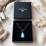 Schmuckbox-Bild MEERESRUHE – Larimar-Halskette aus 925 Silber mit echtem Larimar Tropfen-Anhänger, maritimer Naturstein-Schmuck in schwarzer ZeitlosSchmuckDesign Schmuckbox, handgefertigtes Unikat mit seltenem Blau der Karibik.