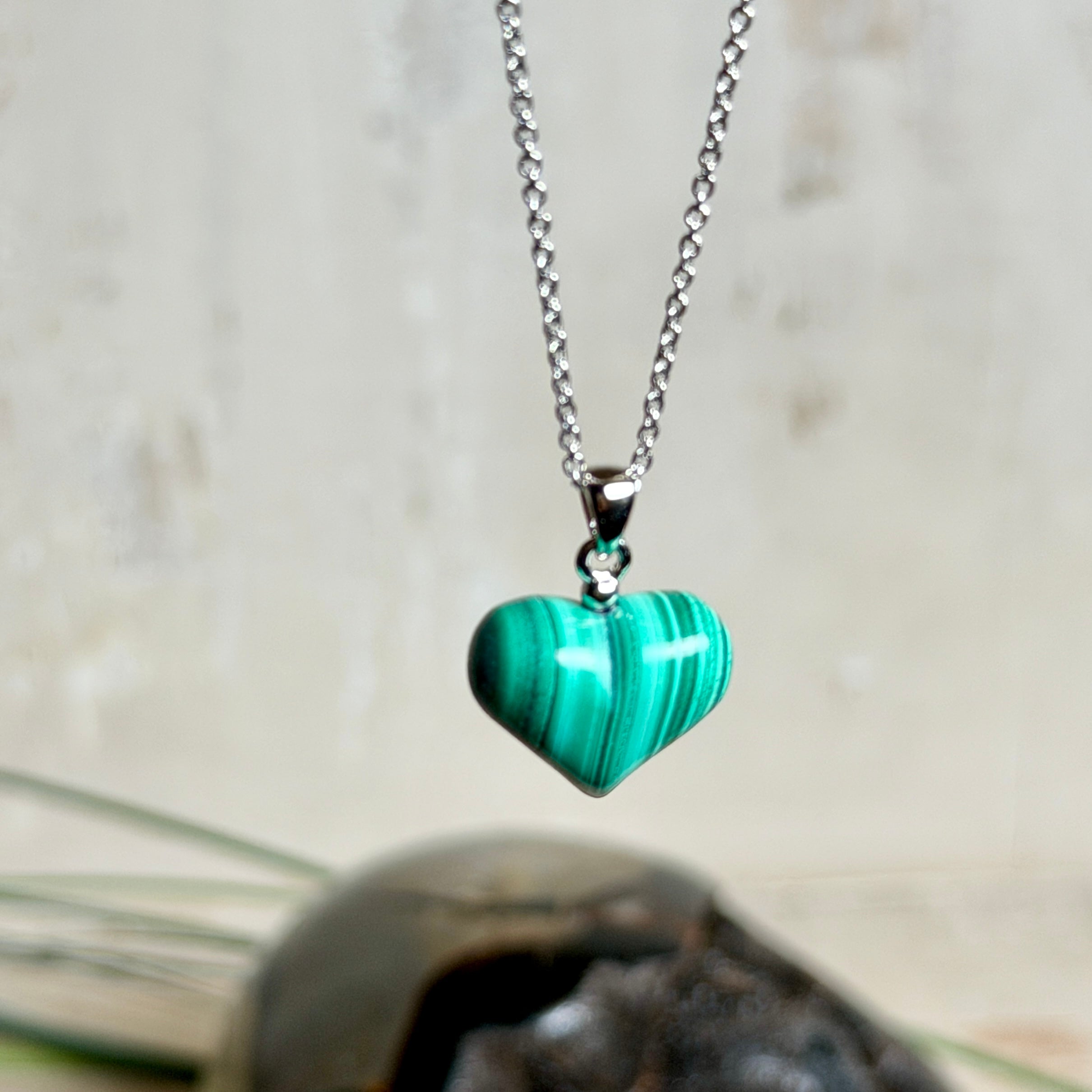 Halskette mit Malachit-Herz: kleiner, gewölbter Herzanhänger aus intensiv grün gebändertem Malachit, ca. 16 x 14 x 10 mm, in hochglanzpolierter, rhodinierter 925 Silberfassung an feiner Ankerkette aus Silber.