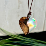 Handgefertigter Herzanhänger aus Olivenholz und schimmerndem Opalharz (Resin Colloidal Imitation Opal) – ein hochwertiges Harz mit feinen, lichtreflektierenden Partikeln, die an echte Opale erinnern. Je nach Licht schimmert der Anhänger in Regenbogenfarben. Mit braunem Lederband und silberfarbener Perle. Jedes Stück ein liebevoll gefertigtes Unikat.