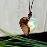 Handgefertigter Herzanhänger aus Olivenholz und schimmerndem Opalharz (Resin Colloidal Imitation Opal) – ein hochwertiges Harz mit feinen, lichtreflektierenden Partikeln, die an echte Opale erinnern. Je nach Licht schimmert der Anhänger in Regenbogenfarben. Mit braunem Lederband und silberfarbener Perle. Jedes Stück ein liebevoll gefertigtes Unikat.