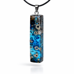 Rechteckiger Stabanhänger aus Maserholz und glasklarem Epoxidharz in tiefen Blau- und Türkistönen mit organischer Lagunen/Riff-Optik. Hochglanzpoliert, ca. 5,3 × 1,2 cm. Der Anhänger hängt an einer schwarzen Lederkette mit Edelstahl-Karabiner und 5-cm-Verlängerung (45 + 5 cm); die Anhängerschlaufe ist ebenfalls aus Edelstahl. Handgefertigtes Unikat, Lieferung in edler Schmuckbox – maritimer Look.