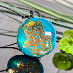 Hamsa Hand Anhänger Epoxidharz türkis gold – rundes Cabochon ca. 4 cm an schwarzem Baumwollband, handgefertigtes Unikat